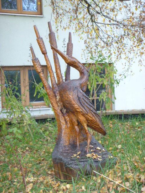 Wooden heron sculpture in garden setting