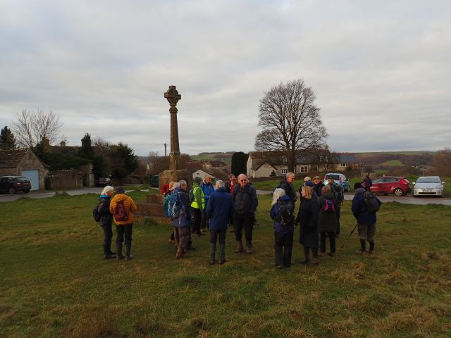 Group of hikers at a countryside monument.